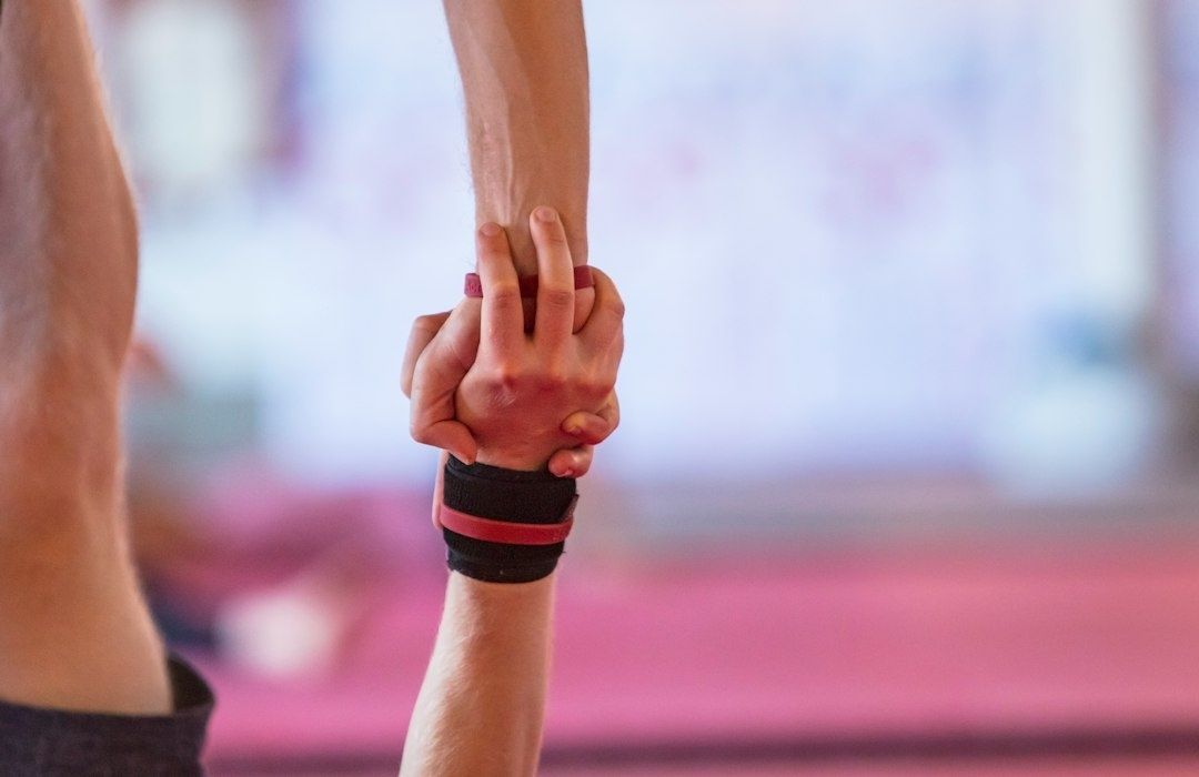 Close-up van een sporter die een hand van een teamgenoot vasthoudt